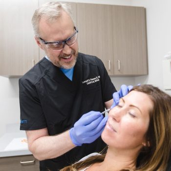 Dr. Hansen injecting Botox into a female patients' forehead.